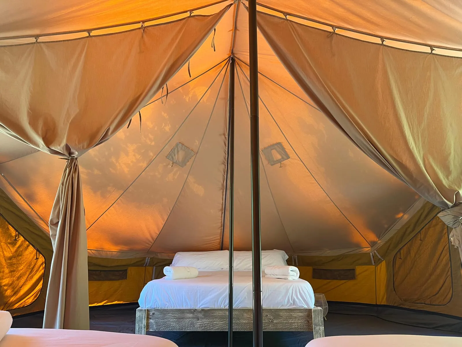 Interior de la tenda Bruc amb llit de matrimoni sota l’estructura de lona