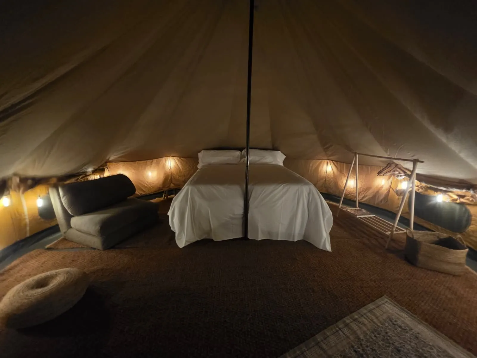 Interior de la tenda Falguera amb llit de matrimoni i il·luminació càlida de nit