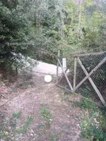 Portalada de malla metàl·lica al costat d’una pista, a l’entrada del càmping
