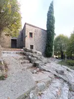 L’església de pedra de Sant Marçal, amb un xiprer i graons de roca